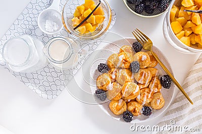 Dutch mini pancakes called poffertjes with blackberries and apple compot Stock Photo