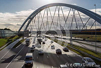 Dutch motorway near Amsterdam with railway bridge and passing train Editorial Stock Photo