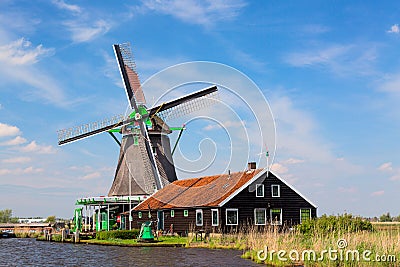 Dutch typical landscape. Traditional old dutch windmill with house blue sky in the Zaanse Schans village, Netherlands. Famous tour Stock Photo
