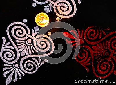 Dutch view of glowing diya and red white rangoli on black background. diwali concept Stock Photo
