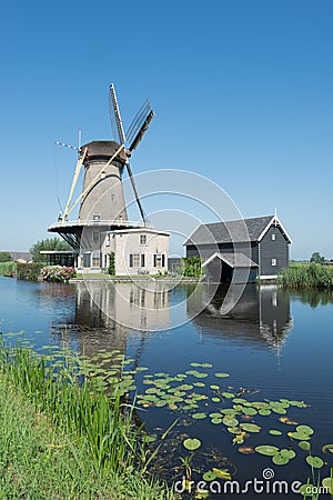 Dutch windmill at a canal on a sunny summer day Stock Photo