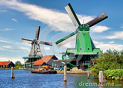 Dutch windmill in green countryside close to Amsterdam, Netherlands, with blue sky and river water Editorial Stock Photo