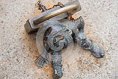 Dwarf with a padlock near bridge. Small bronze figures of gnomes on the streets of Wroclaw. Europe Miniature bronze Editorial Stock Photo