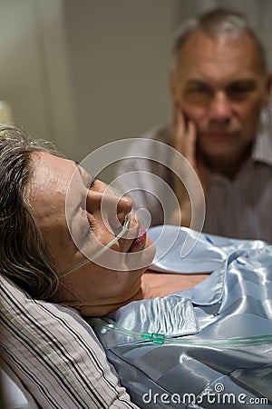 Dying woman in bed with caring man Stock Photo