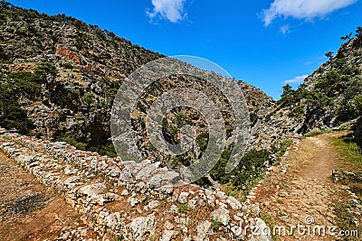 Dynamic composition of typical Greek landscape, hills, fresh spring greenery, paved paths crossing. Avlaki gorge of Stock Photo