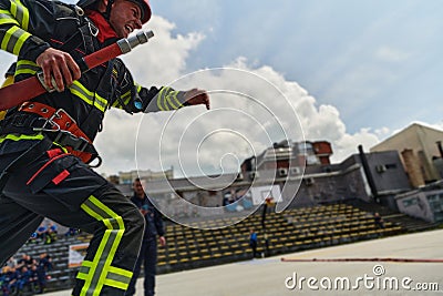 In a dynamic display of synchronized teamwork, firefighters hustle to carry, connect, and deploy firefighting hoses with Stock Photo