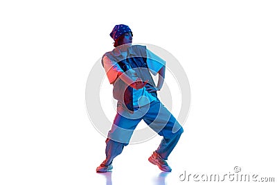 Dynamic image of young girl in casual sportive cloths dancing hip hop isolated over white background in neon light Stock Photo