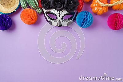 DÃ­a de los Muertos day of the dead holiday concept. Sugar skull mask and Mexican party decorations on purple background. Top view Stock Photo