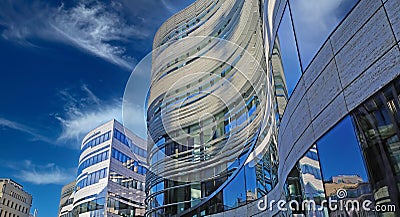 View on curved arched facade, blue modern windows in combination with white natural stone against clear sky , fluffy clouds Editorial Stock Photo