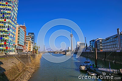 View over water canal beyond modern buildings on rhine tower against blue sky Editorial Stock Photo