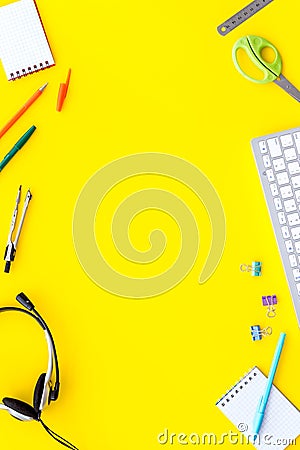 E-learning. Stationery, headphones and keyboard on yellow table top-down frame copy space Stock Photo