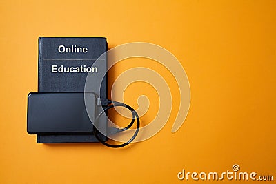 E-library. E-learning, online education or e-book. Webinar, internet courses. Book and hard drive on yellow background Stock Photo