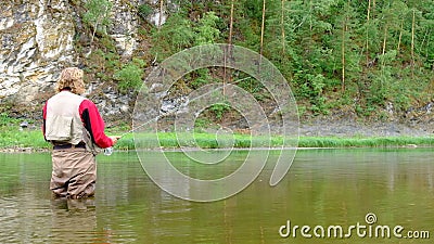 Ein Fischer mit Angelrute steht im Fluss Altenflieger des Weihnachtsmannes Sport, Outdoor-Erholung in den Bergen stock footage Ein Fischer mit Angelrute steht im Fluss Altenflieger des Weihnachtsmannes Sport, Outdoor-Erholung in den Bergen stock footage