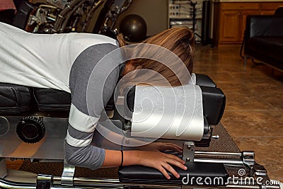 Side View of a Girl Laying on a Tilted Chiropractic Table Stock Photo