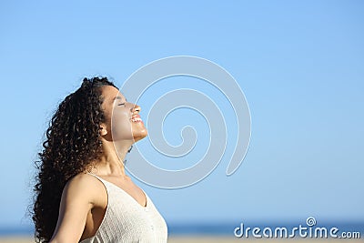 Relaxed young woman breating and enjoying sun on the beach Stock Photo