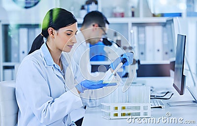 Each dosage, carefully measured. an attractive young female scientist working in her lab with a colleague in the Stock Photo