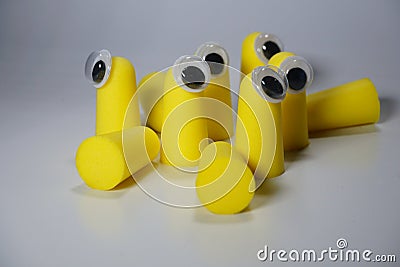 Ear plugs against hearing damage. Yellow plastic puffs in the ear that reduce noise and a quiet night's sleep. Stock Photo