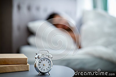 Early awakening concept. Man sleeping through alarm clock in the morning, lying in bed Stock Photo