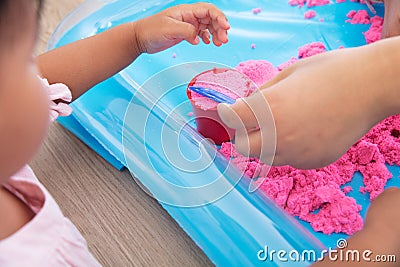 Early childhood children are happily playing in the space sand Stock Photo