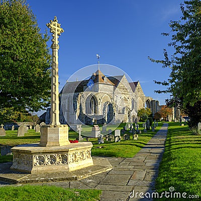 Early evening autumn light on St Thomas the Martyr church and village cross, Winchelsea, East Sussex, UK Editorial Stock Photo