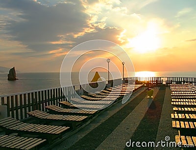 Early morning. Sunrise. Empty sunbeds on the terrace over sea. Stock Photo