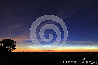 Early morning sunrise glow reflected in wispy clouds Stock Photo