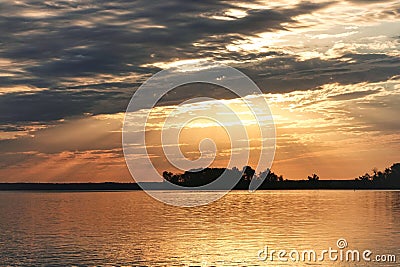 Early morning sunrise with sunrays poking through clouds over Rend Lake in Illinois Stock Photo