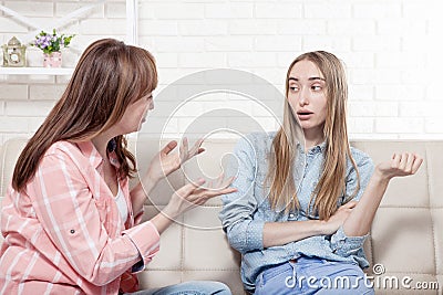 Early pregnancy. Mother and daughter are sitting on sofa at home background. Copy space and mock up Stock Photo