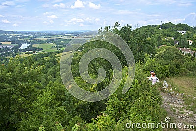 In early summer sunshine two people consider the view over the Lot River and Valley from hilltop Penne d`Agenais Editorial Stock Photo