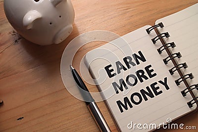 Earn more money, text words typography written on book against wooden background, life and business motivational inspirational Stock Photo