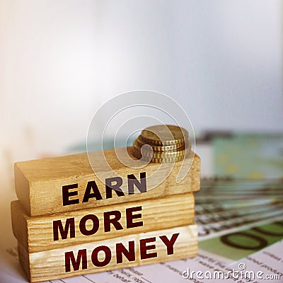 Earn More Money on wooden blocks, coins and bills. Business and career concept Stock Photo