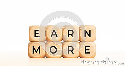 Earn more phrase on wooden block shape Stock Photo