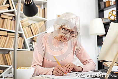 Earnest senior woman composing essay Stock Photo