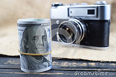 Earnings in photography, a camera and money dollars are on the table Stock Photo