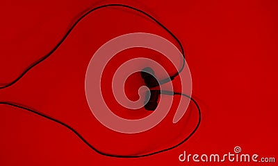 Earphone.Black earphone on Red backgroud. Stock Photo