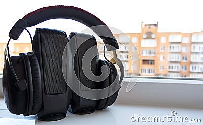 Earphones on musical loudspeakers close up. Headphones on stereo speakers Stock Photo