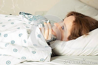 Earplugs by a woman in bed after a healthy sound sleep without the noise of neighbors Stock Photo