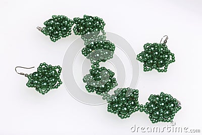 Earrings and bracelet handmade. Needlework at home. Bead jewelery. Green colour. On a white background. Stock Photo