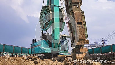 Earth drilling crawler crane with hydraulic diaphragm wall equipments working in road construction site Stock Photo