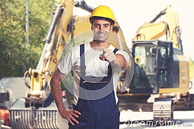 Earthmover with pointing latin american construction worker Stock Photo