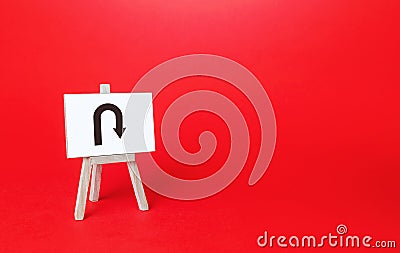 Easel with arrow turning back. Change plans, circumstances. Avoiding problems, reducing risks. Reassessment of actions. Break a Stock Photo