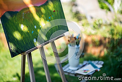 Easel with canvas art painting outdoors in a garden. Mindfulness, art therapy and creative hobbies concept. Stock Photo