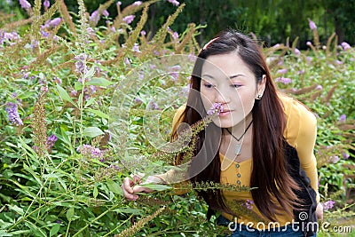 East asian woman bending over picking flowers Stock Photo