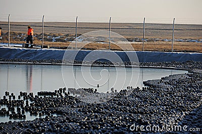 East Kazakhstan region, Kazakhstan - 12.02.2015 : The chemical tank is covered with plastic balls to slow evaporation Editorial Stock Photo
