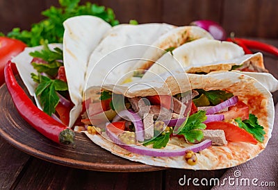 East pita bread with various fillings (meat, salami, egg, cucumber, parsley, tomato, chili pepper, Dijon mustard). Stock Photo