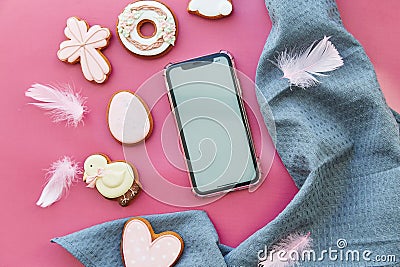 Easter aesthetics cookies and mockup of screen phone on pink background flat lay. Happy Easter Stock Photo