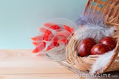 Easter eggs, colored an onions peel, in a basket on a wooden background Stock Photo