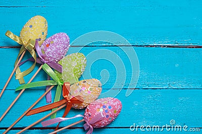 Easter background. Multicolored decorated easter eggs, multi-colored powder on a turquoise background. Free space Stock Photo