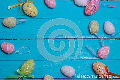 Easter background. Multicolored decorated easter eggs, multi-colored powder on a turquoise background. Free space Stock Photo