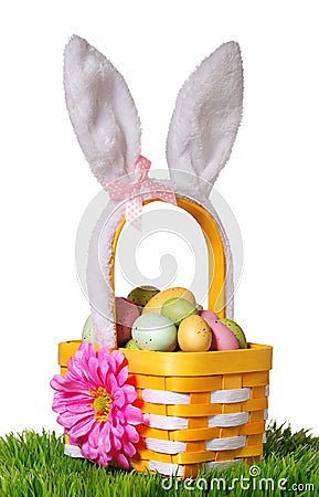 Easter basket with colorful eggs and bunny ears on green grass Stock Photo